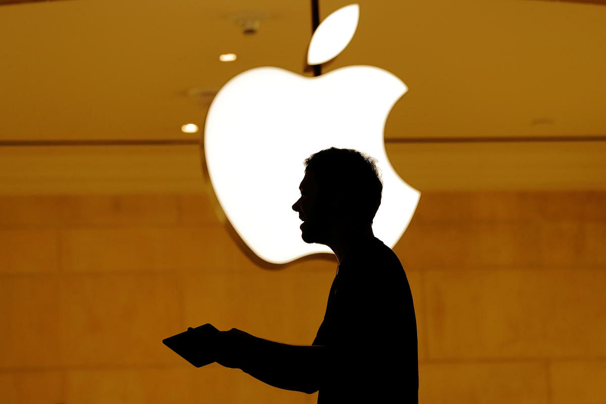Customers walk past an Apple logo inside of an Apple store at Grand Central Station in New York. REUTERS