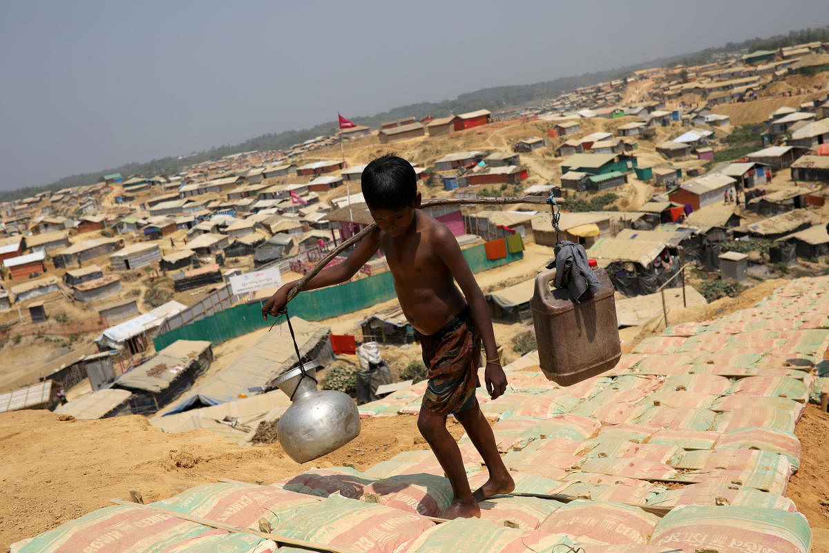 FILE PHOTO: A Rohingya refugee boy carries water in the Kutupalong refugee camp, in Cox's Bazar, Bangladesh March 22, 2018. REUTERS/Mohammad Ponir Hossain/File Photo