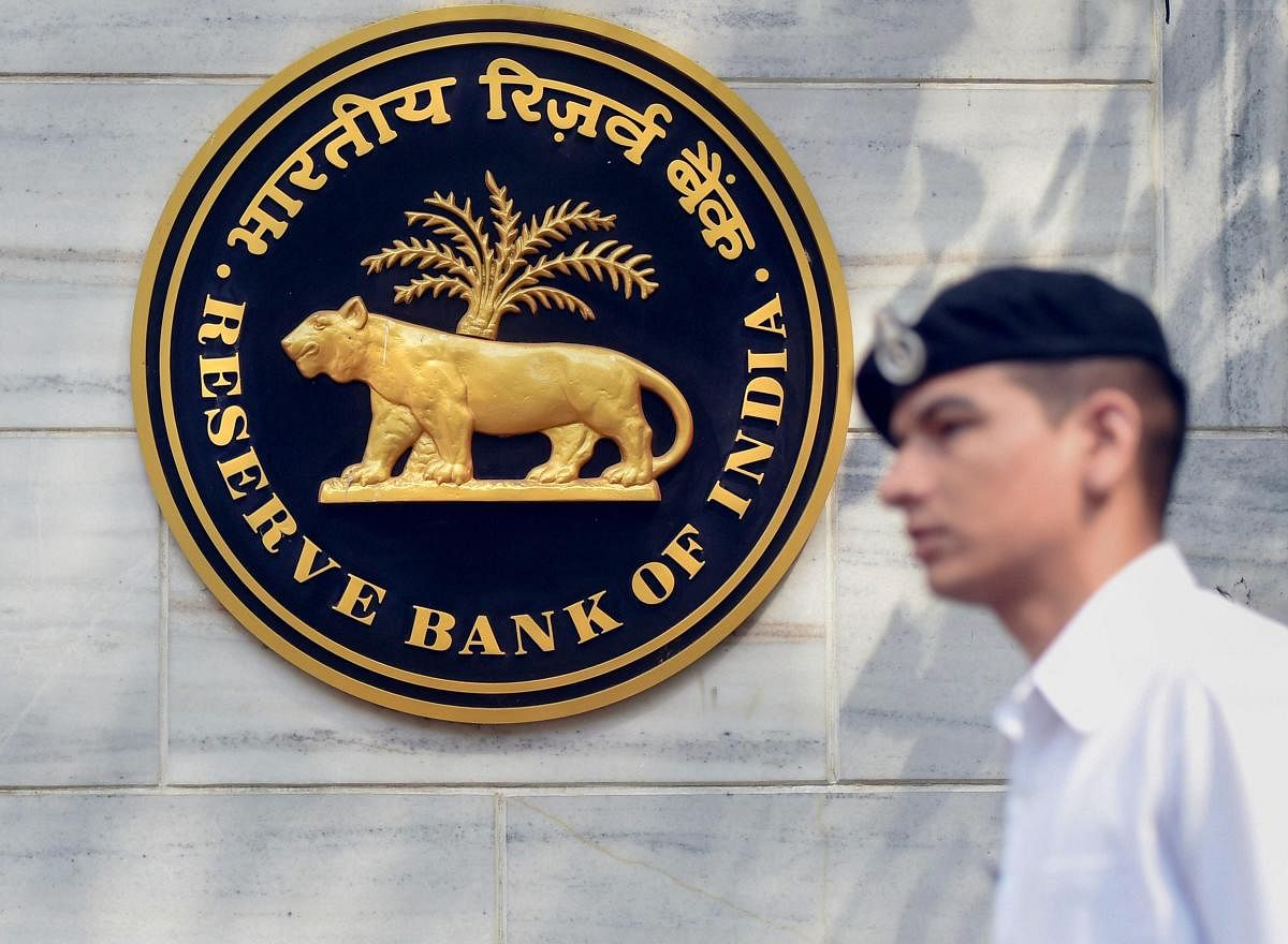 Mumbai: An Indian Navy officer walks past the emblem of Reserve Bank of India (RBI) at RBI head office in Mumbai on Thursday. PTI Photo by Shashank Parade(PTI4_5_2018_000197A)