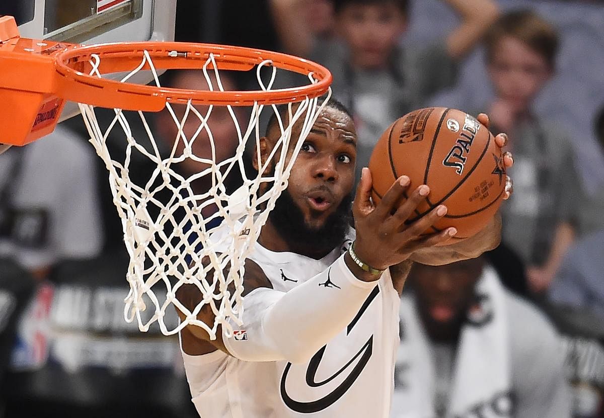 (FILES) In this file photo taken on February 18, 2018 LeBron James sinks a basket during the 2018 NBA All-Star Game at Staples Center in Los Angeles, California. Basketball great LeBron James on July 31, 2018 accused President Donald Trump of intensifying