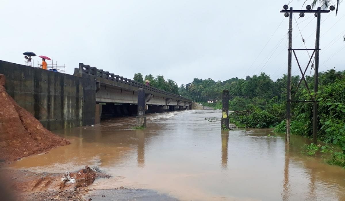 The inundated Hosamata bridge near Kadaba. As work on the new bridge is incomplete, vehicles use the old bridge.