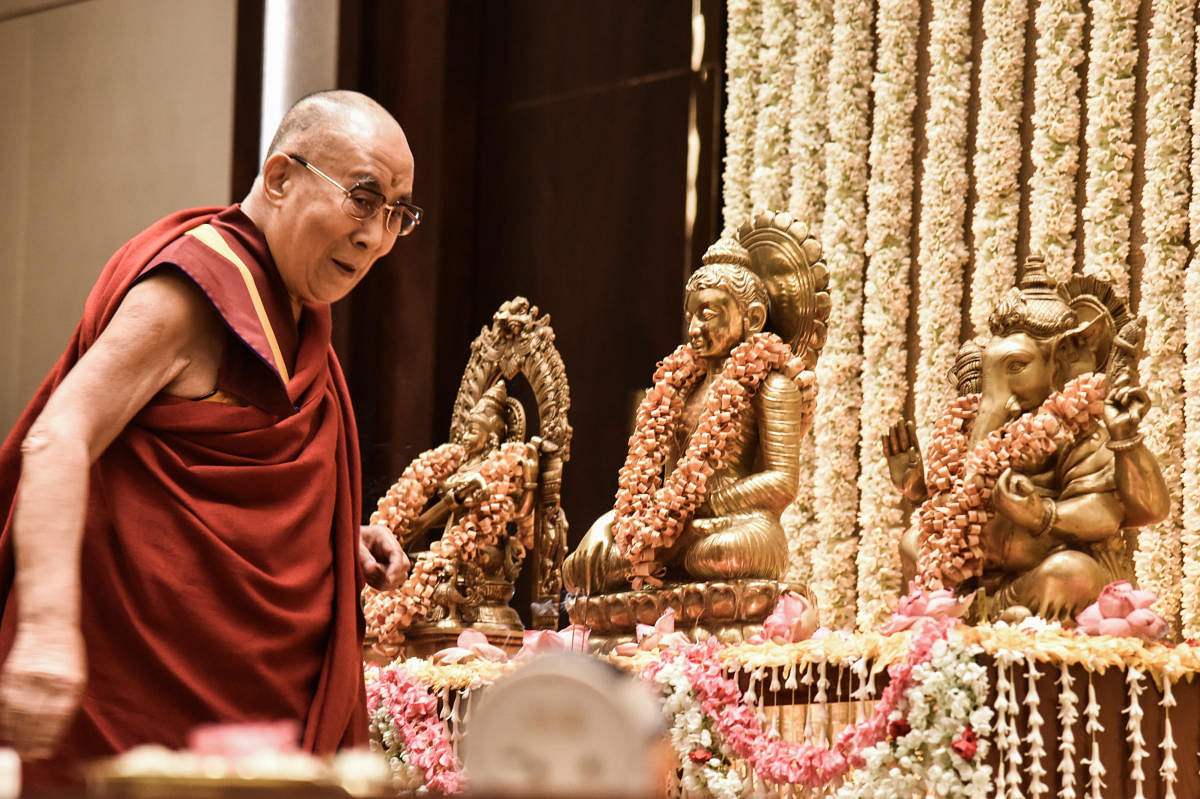 The 14th Dalai Lama offers prayer at a programme in Bengaluru on Saturday. DH Photo