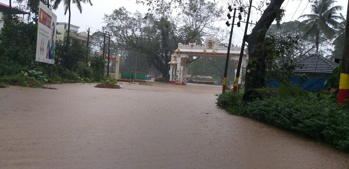 Water from the Kumaradhara river has inundated the road leading to the Kukke Subrahmanya Temple. (DH Photo)