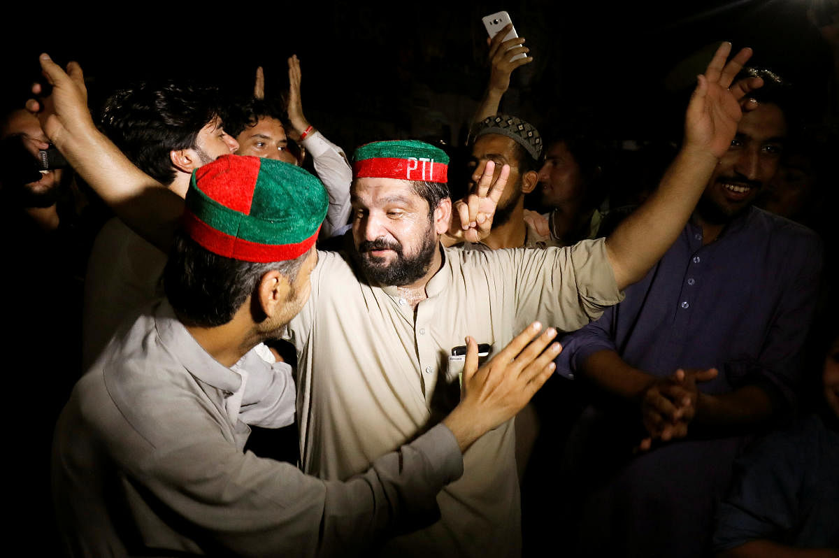 Supporters of Imran Khan, chairman of Pakistan Tehreek-e-Insaf (PTI) gesture to celebrate after Khan was elected as Prime Minister, in Peshawar, Pakistan August 17, 2018. (Reuters Photo)