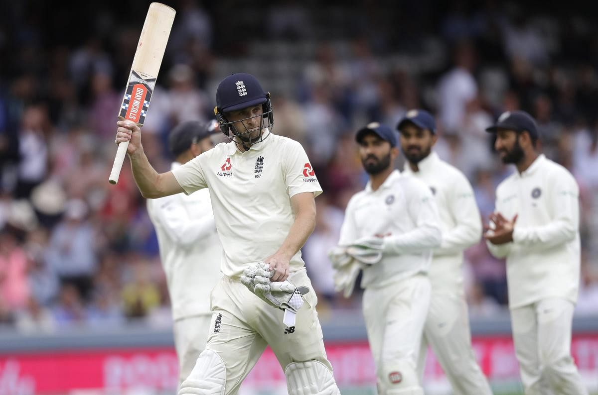 England's Chris Woakes is applauded by the Indian team as he leaves the pitch on 120 not out after bad light stopped play, during the third day of the second test match between England and India at Lord's cricket ground in London.