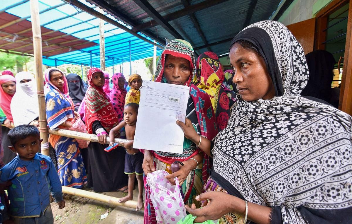People wait to check their names on the final draft of the state's National Register of Citizens after it was released, at an NRC Seva Kendra in Nagaon. PTi
