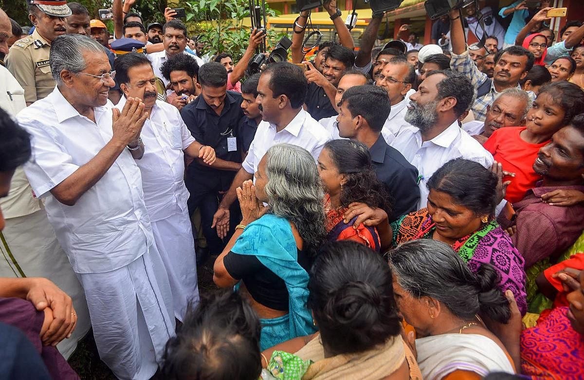 Kerala Chief Minister Pinarayi Vijayan interacts with the flood-affected people at a relief camp in Ernakulam on Saturday. PTI