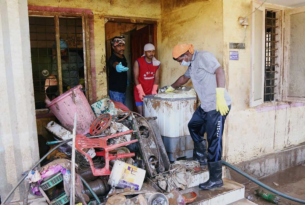 Volunteers clean a house following floods on the outskirts of Kochi, Kerala. Reuters Photo