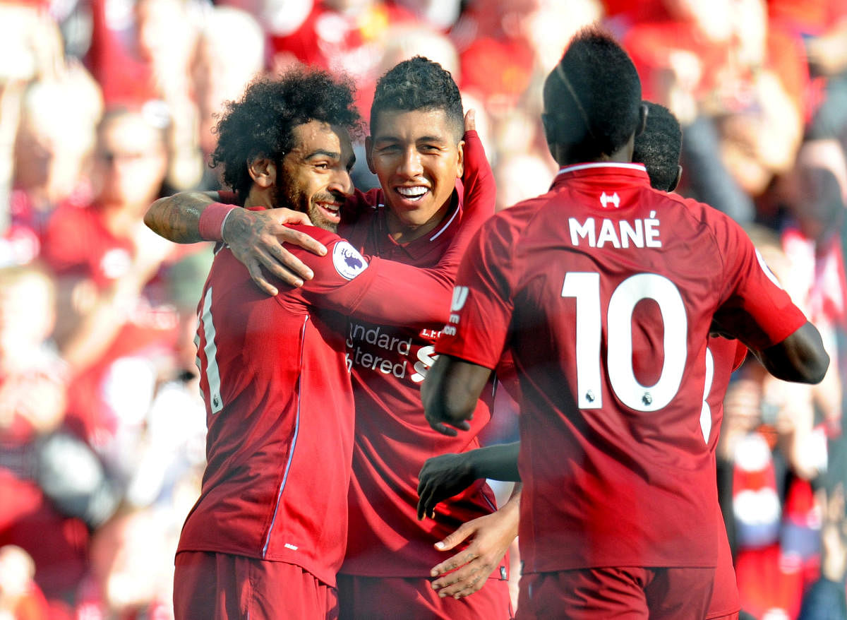 Liverpool's Mohamed Salah (left) celebrates with Roberto Firmino (centre) after scoring against Brighton on Saturday. REUTERS