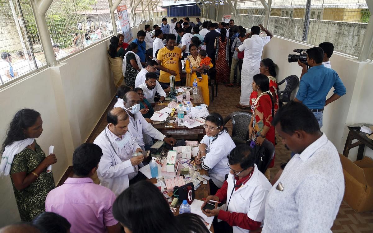Doctors monitor the health of flood victims inside SDVP school classroom converted into a temporary relief camp, in Alleppey on Sunday. PTI