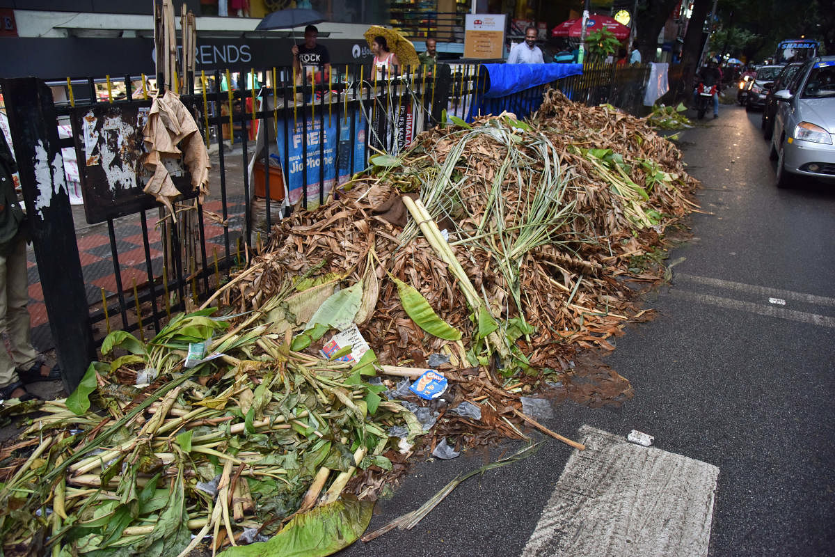 An uncleared garbage pile after Varamahalakshmi festival on Malleswara 8th Cross on Sunday. DH PHOTO/Janardhan B K
