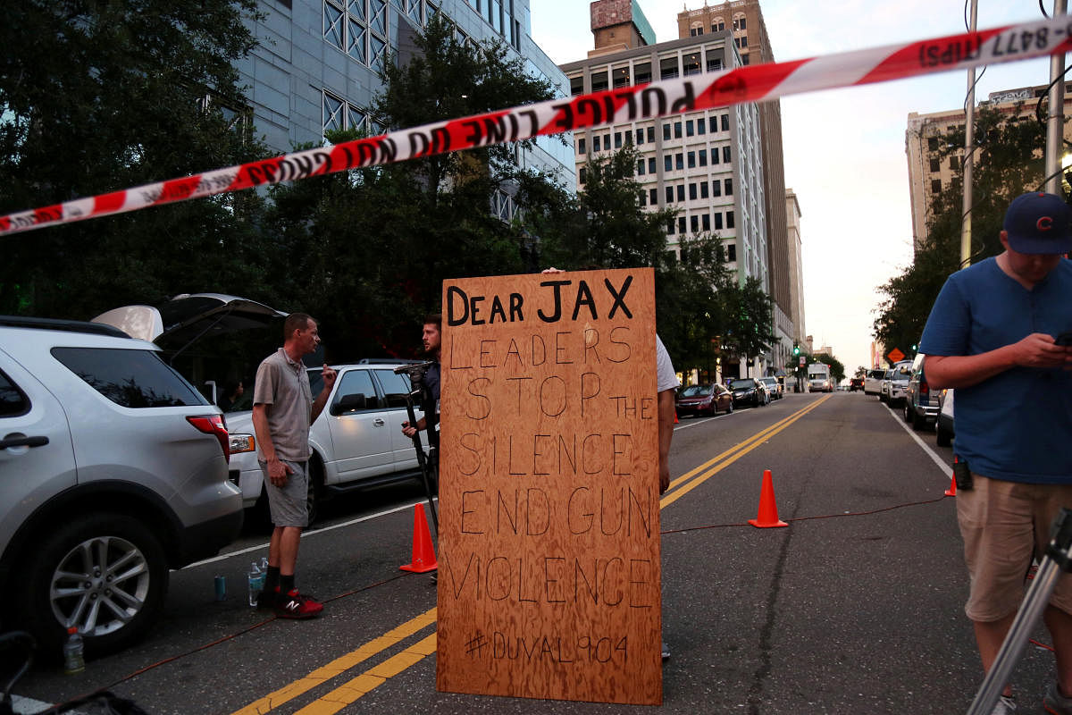 A man holds a sign in support of gun control outside of The Jacksonville Landing after a shooting in Jacksonville, Florida August 26, 2018. (REUTERS)