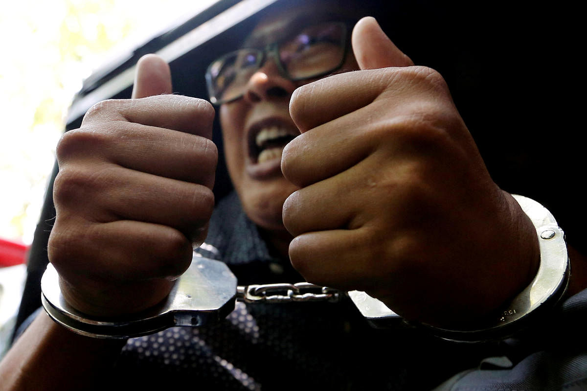 Detained Reuters journalist Wa Lone gestures to the media as he is escorted by police after a court hearing in Yangon, Myanmar April 11, 2018. (REUTERS File Photo)