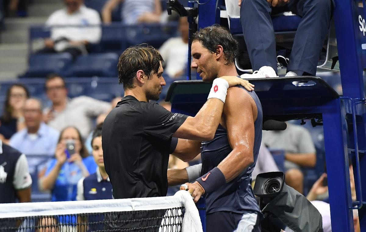 GOOD FRIENDS: Spaniards Rafael Nadal (left) and David Ferrer talk at the net after the latter retired during their US Open men's singles match. AFP