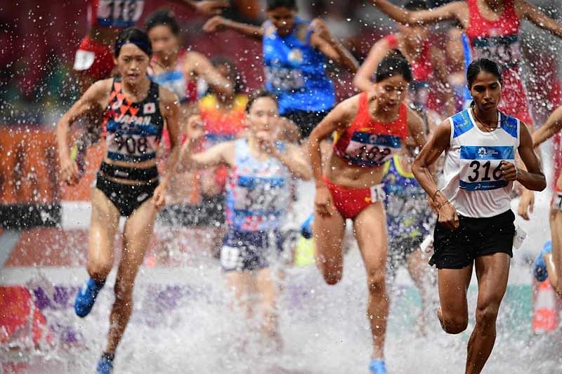 Sudha Singh (R) leads in the final of the women's 3000m steeplechase athletics event during the 2018 Asian Games in Jakarta. (AFP Photo)