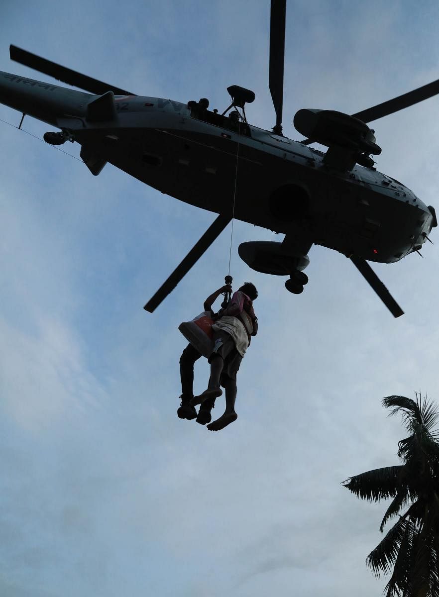 A man being airlifted by Navy personnel during a rescue operation at a flooded area in Paravoor near Kochi, Kerala. AFP