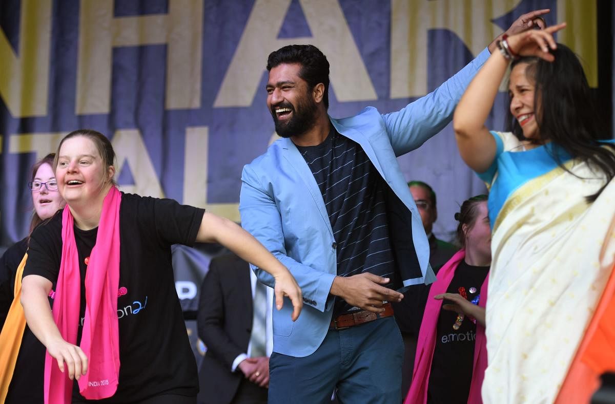 Vicky Kaushal (C) dances on stage with performers in Federation Square at the Indian Film Festival of Melbourne on August 11, 2018. (Photo AFP)