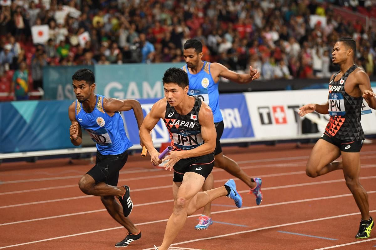 Japanese (front) and Indian athletes compete in the final of the men's 4x400m relay athletics event during the 2018 Asian Games in Jakarta on August 30, 2018. (Photo by Anthony WALLACE / AFP)