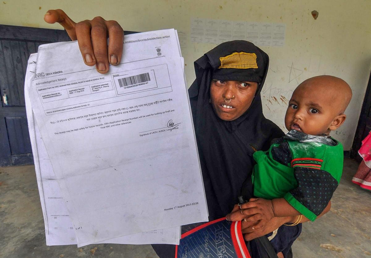 A woman shows an acknowledgment receipt to check her name in the final draft of Assam's National Register of Citizens at an NRC Seva Kendra in Morigaon. PTI