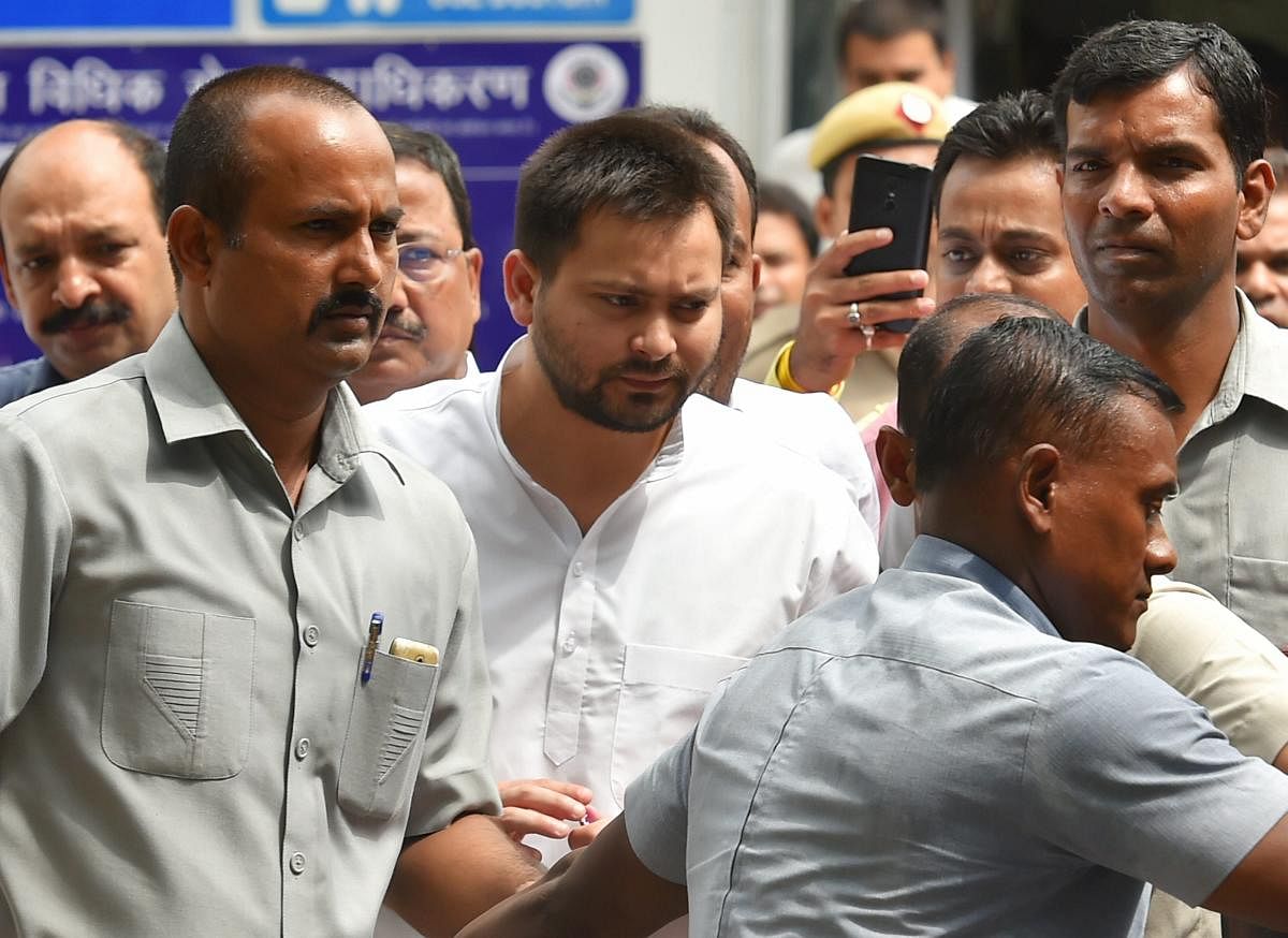 Tejashwi Prasad Yadav (C) son of former Bihar chief minister Lalu Prasad Yadav, comes out of Patiala House court after appearing before a special court in the (IRCTC) tender scam case, in New Delhi on Friday. PTI