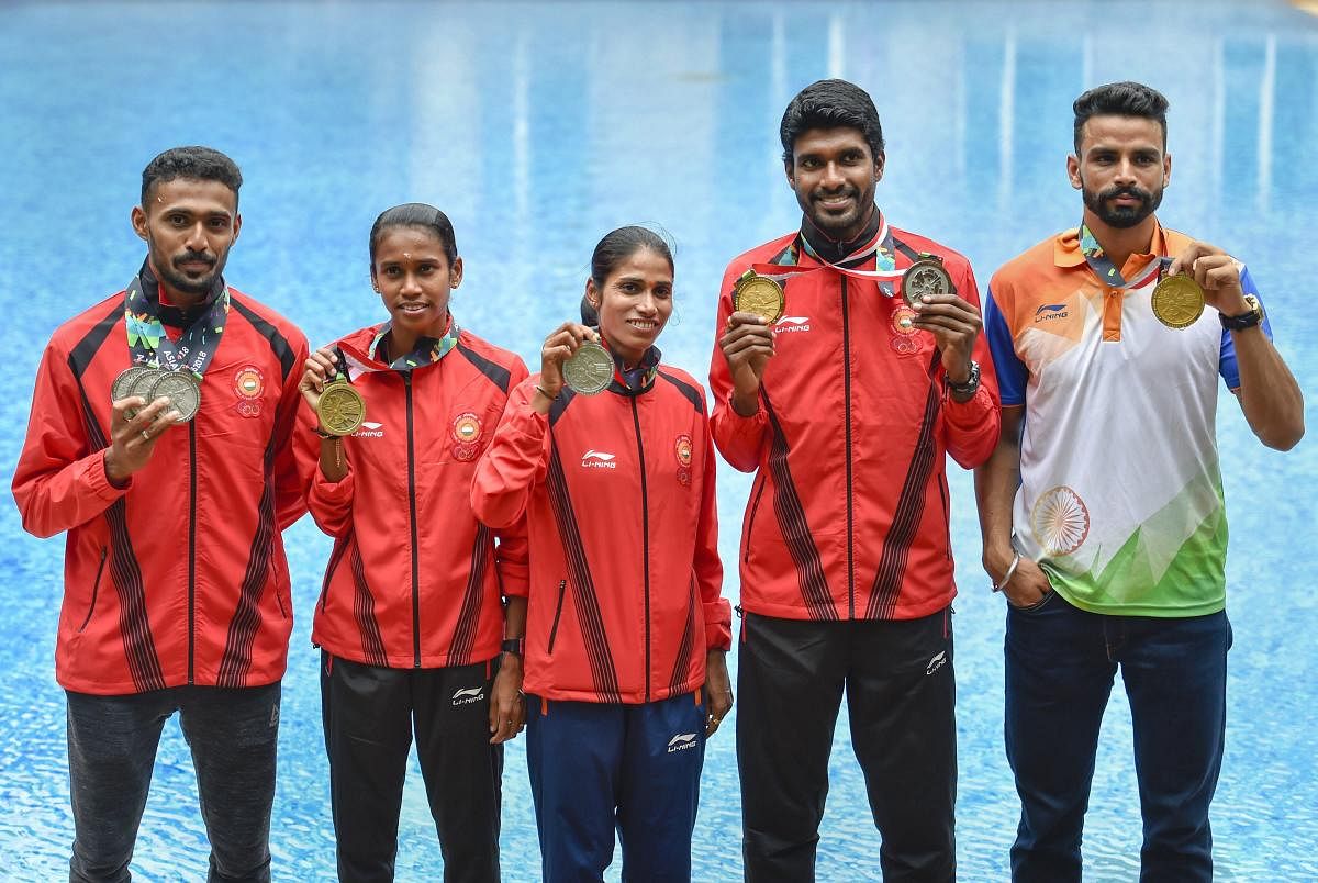 Indian Athletes (L-R) Md. Anas, PU Chitra, Sudha Singh, Jinson Johnson and Arpinder Singh with their Asian Games medals in New Delhi. PTI