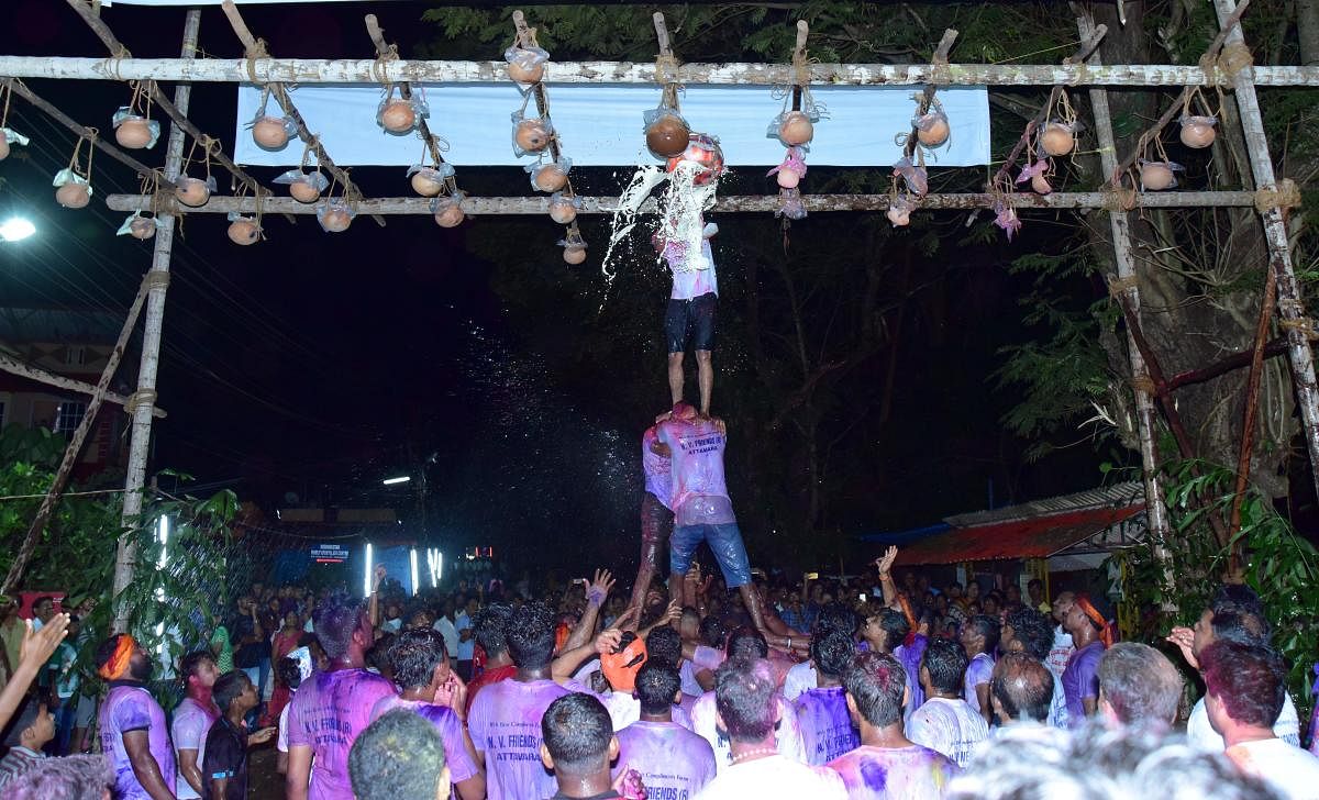Youth form a pyramid and burst the pots containing curd, during Mosaru Kudike celebrations at Attavar in Mangaluru on Monday.