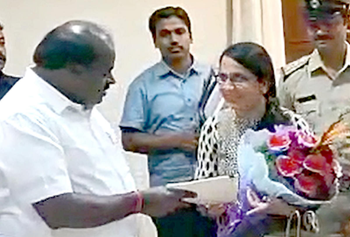 Chief Minister H D Kumaraswamy gives the flat documents to Vandana Kukreja in Bengaluru on Tuesday. 