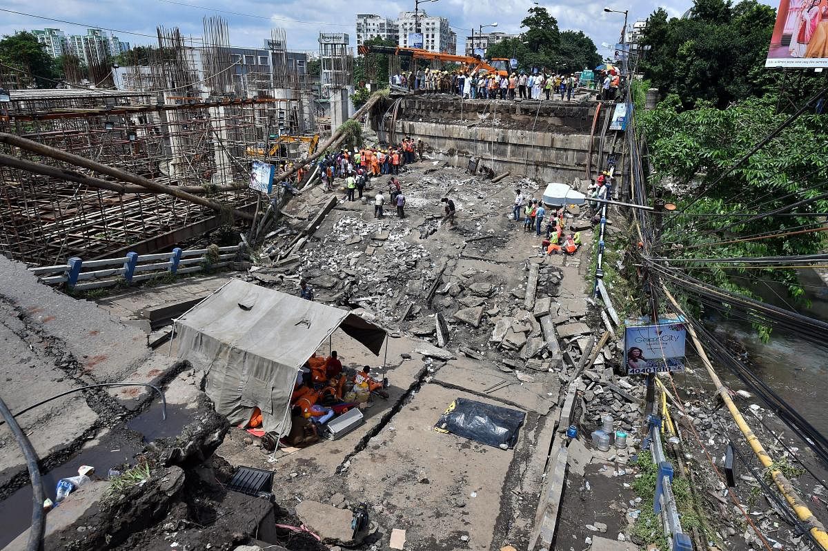 DRF team members take a break under a tent during rescue operations after the collapse of Majerhat bridge, in Kolkata. (PTI Photo)