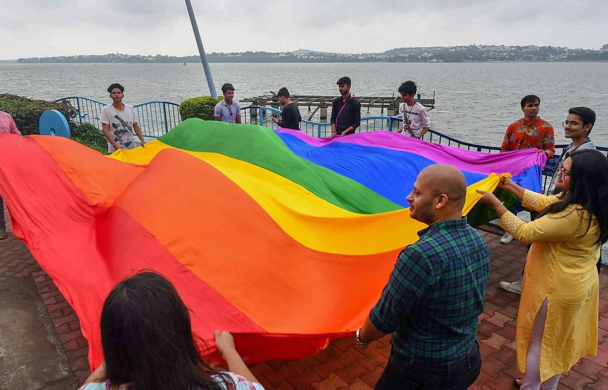 LGBTQ members celebrate the Supreme Court verdict which decriminalises consensual gay sex on the bank of Upper Lake, in Bhopal. (PTI Photo)