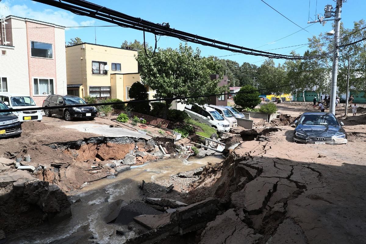 A car is stuck on a road damaged by an earthquake in Sapporo, Hokkaido prefecture on September 6, 2018. AFP