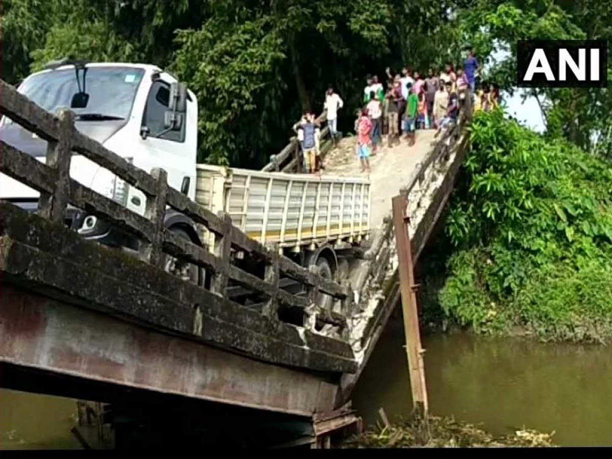 The truck, which was crossing the bridge, is still hanging from the broken portion of the structure that connects Manganj area to Siliguri, a major city in north Bengal. (Image courtesy ANI/Twitter)