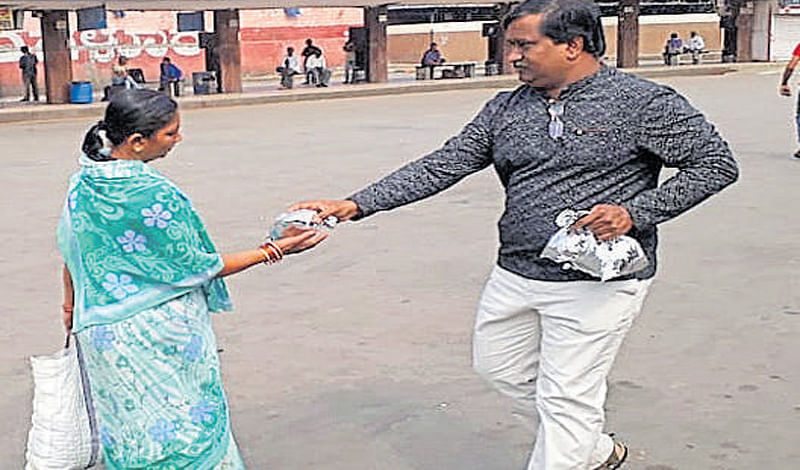 A citizen distributes food packets to stranded passengers in the Kempegowda bus station.