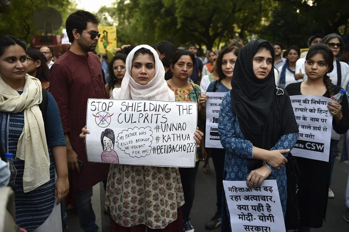 People display placards as they take part in 'Not In My Name' protest against the recent incidents of rapes, at Parliament Street in New Delhi on Sunday. PTI Photo
