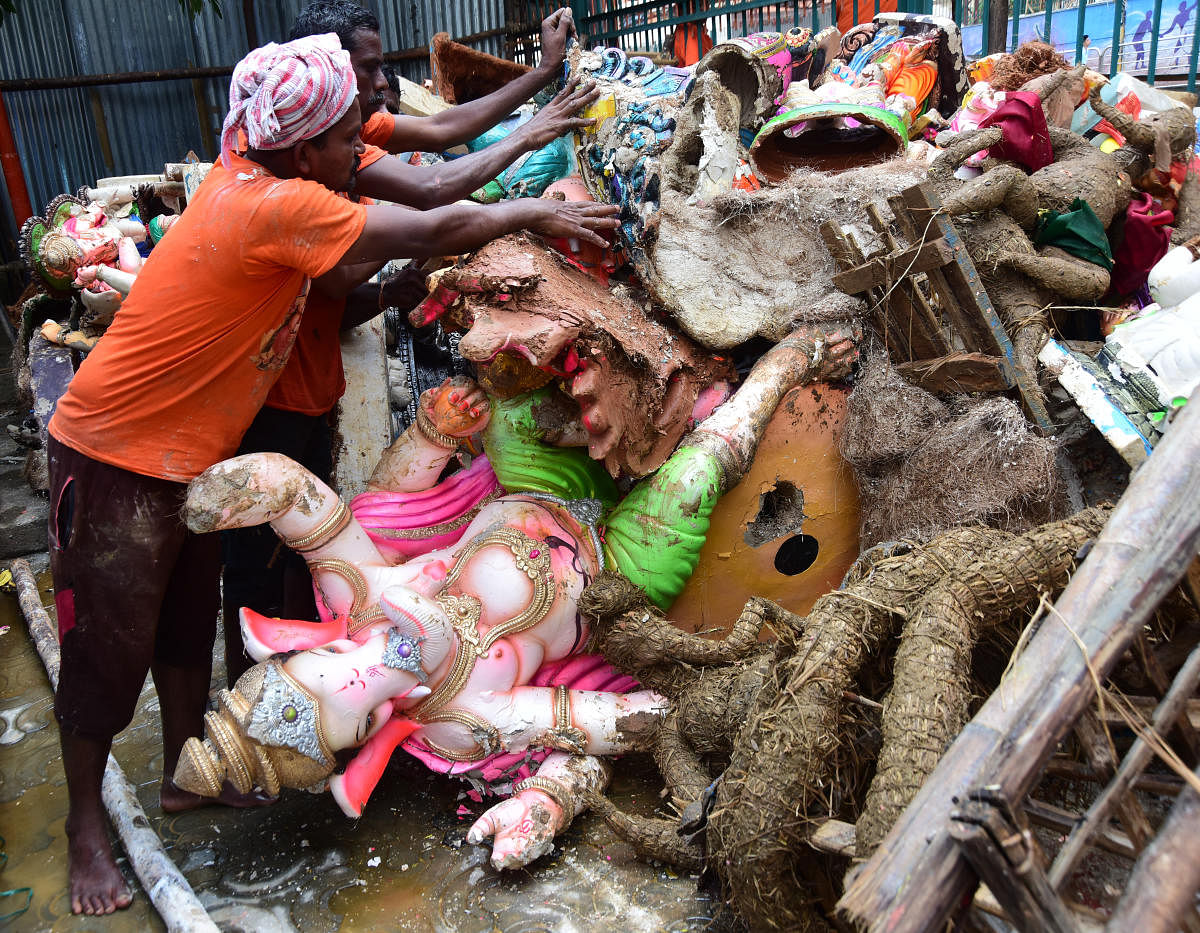 BBMP workers clear the immersed idols from Yediyur tank on Friday. DH photo