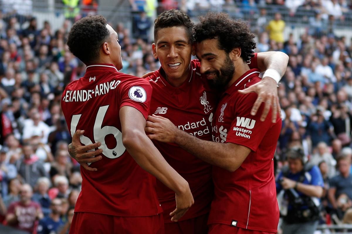 Fantastic run: Liverpool's Roberto Firmino (centre) celebrates with Trent Alexander-Arnold (left) and Mohamed Salah after scoring against Tottenham Hotspur on Saturday. AFP