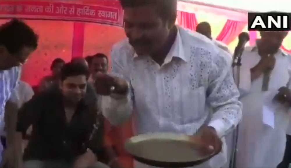 BJP supporter drinking water after washing the feet of BJP MP Nishikant Dubey. Picture courtesy ANI