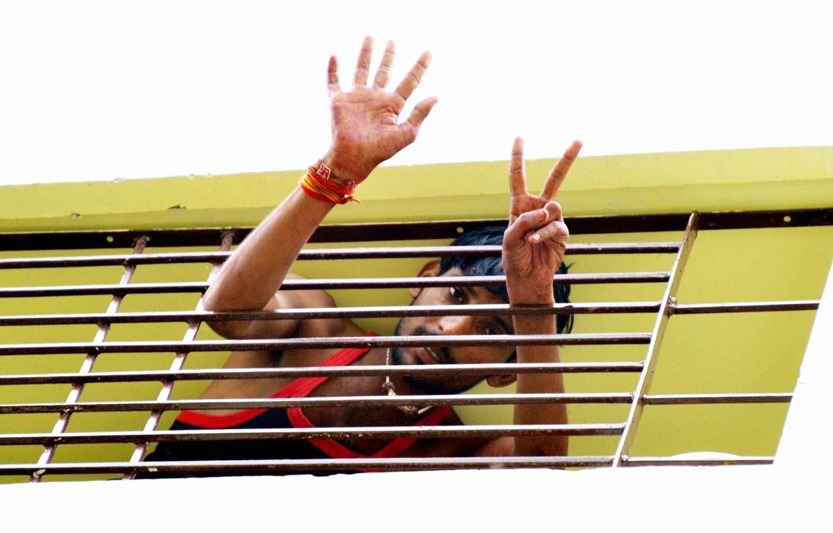 A jilted youth gestures after keeping a girl hostage for over twelve hours, in a residential flat, in Bhopal on Friday, July 13, 2018. (PTI Photo) 