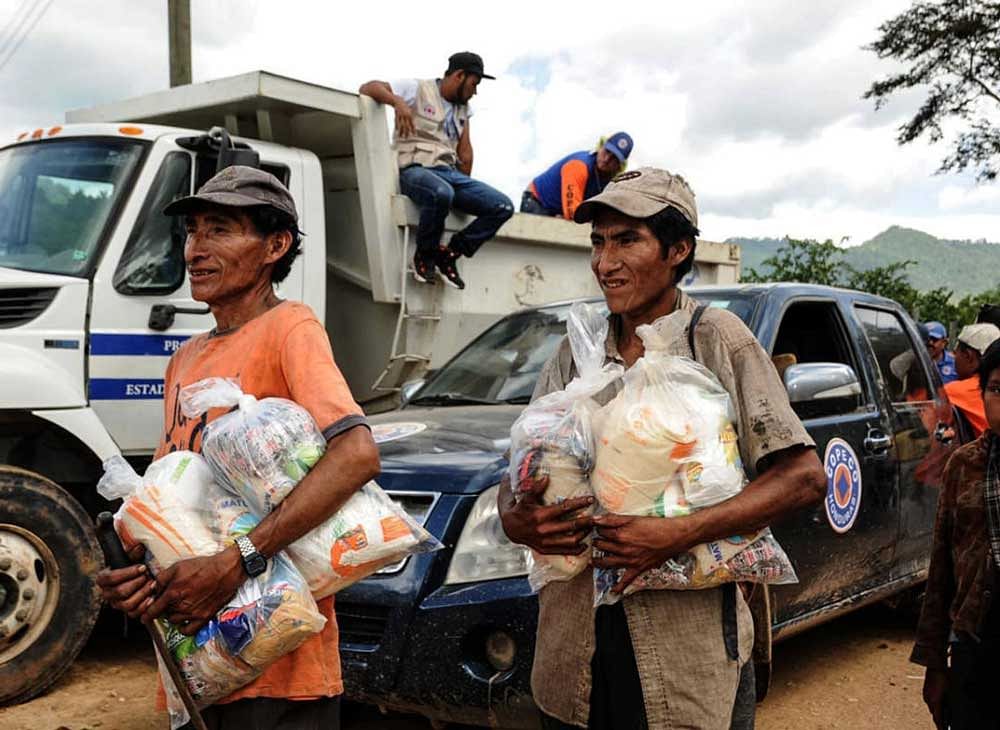 Honduran Tolupan natives and ladino people, receive food donations from the government at the Montana de la Flor, in Francisco Morazan department, Honduras on September 01, 2018. - At least 600 families from five different indigenous communities are facing starvation due to the loss of their crops, after the sever droughts caused by the El Nino climate phenomenon. AFP 