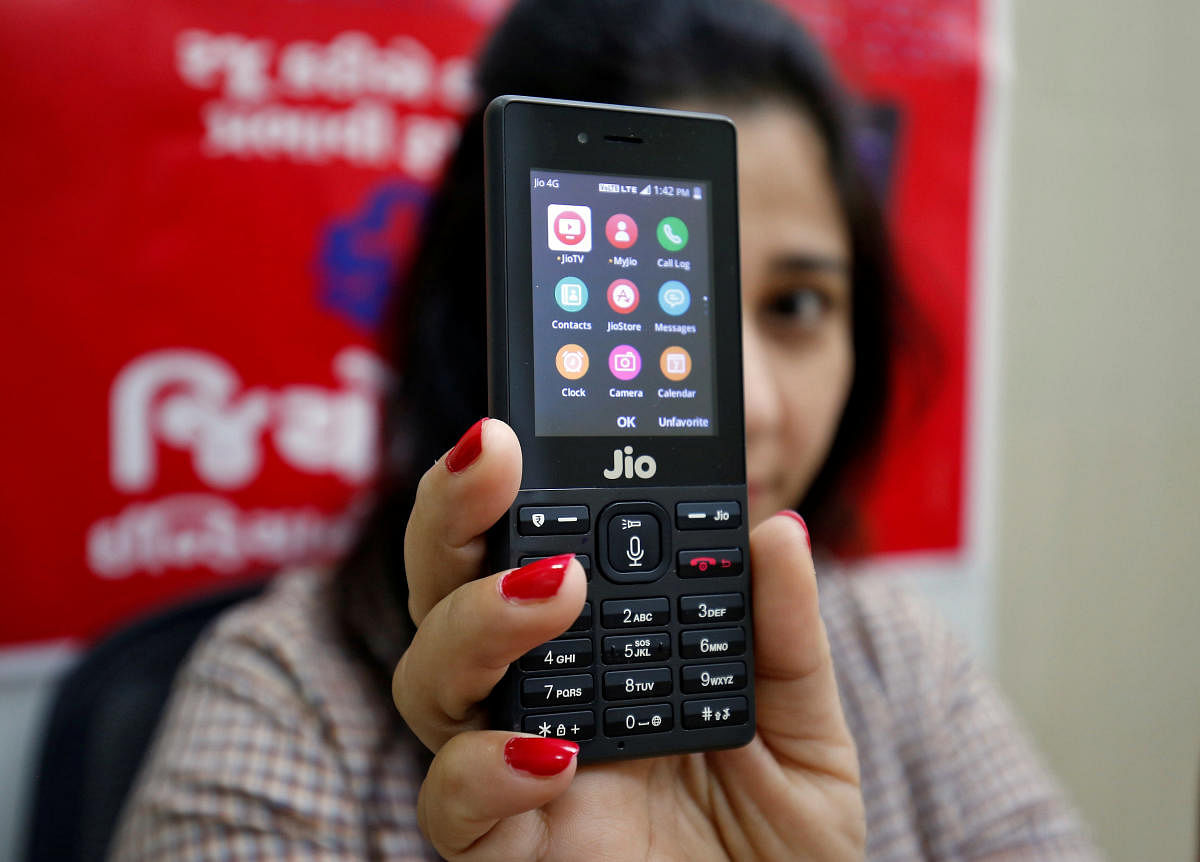 A sales person displays JioPhone as she poses for a photograph at a store of Reliance Industries' Jio telecoms unit. REUTERS
