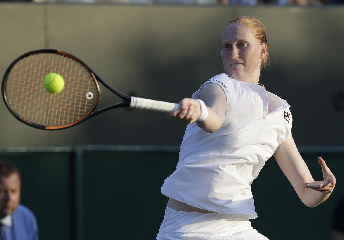 Alison Van Uytvanck of Belgium returns the ball to Garbine Muguruza of Spain during their women's singles match on the fourth day at the Wimbledon Tennis Championships in London, Thursday July 5, 2018. AP/PTI