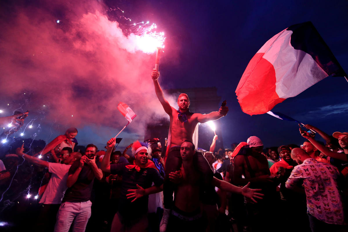 France fans celebrate in front of the Arc de Triomphe on the Champs-Elysees Avenue after France won the Soccer World Cup final. Reuters