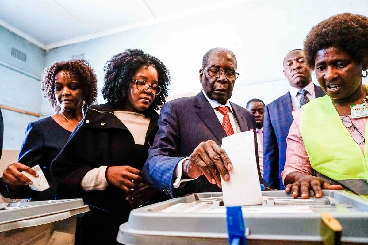 Former Zimbabwean president Robert Mugabe (centre) his daughter Bona and wife Grace cast their votes at a polling station at a primary school in the Highfield district of Harare during the country's general elections on July 30, 2018. AFP