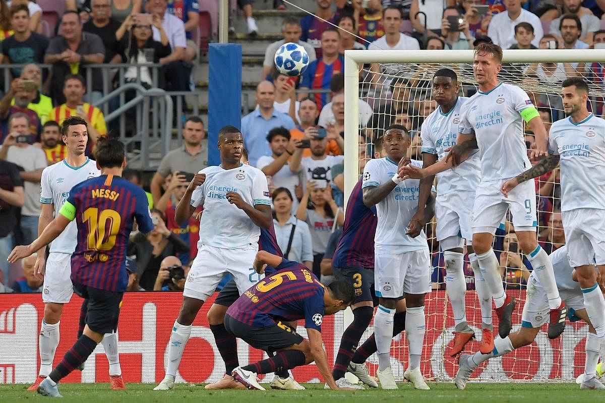 Barcelona's Lionel Messi (left) scores off a freekick during their clash against PSV Eindhoven at Camp Nou on Tuesday. AFP
