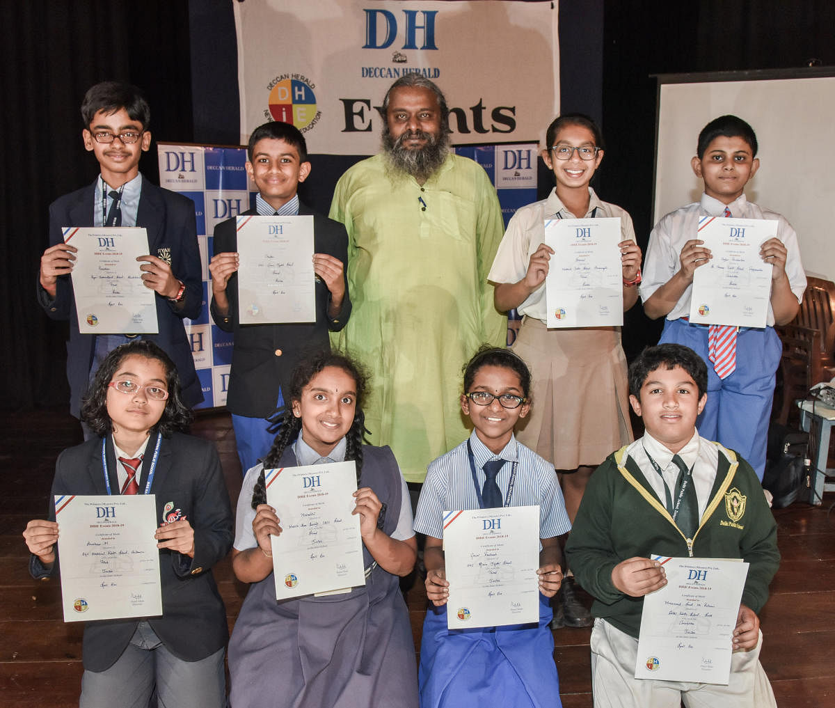 Senior category (standing from Left) Preetham R, Ryan International School (First), Chandan U Hande, HAL Gnanajyothi (Second), Sharvari P B, National Public School Koramangala (Third) and Arjun Ravisankar, St Thomas Public School (Consolation). Junior category(sitting from left) Anushree Maitra, BGS National Public School (First), Mrinalini, Mahila Seva Samaj (Second), Gauri Pradeesh (Third) and Mohammed Saad ur Rahman, DPS South (Consolation) with Prof Arul Mani (centre). (DH Photo/S K Dinesh)