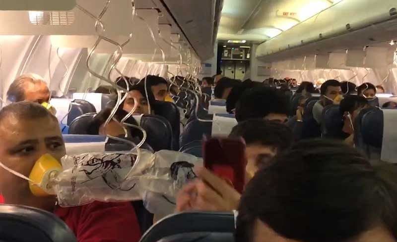 Passengers wearing oxygen mas inside the Jet Airways flight. Screengrab. Source: Twitter/DarshakHathi