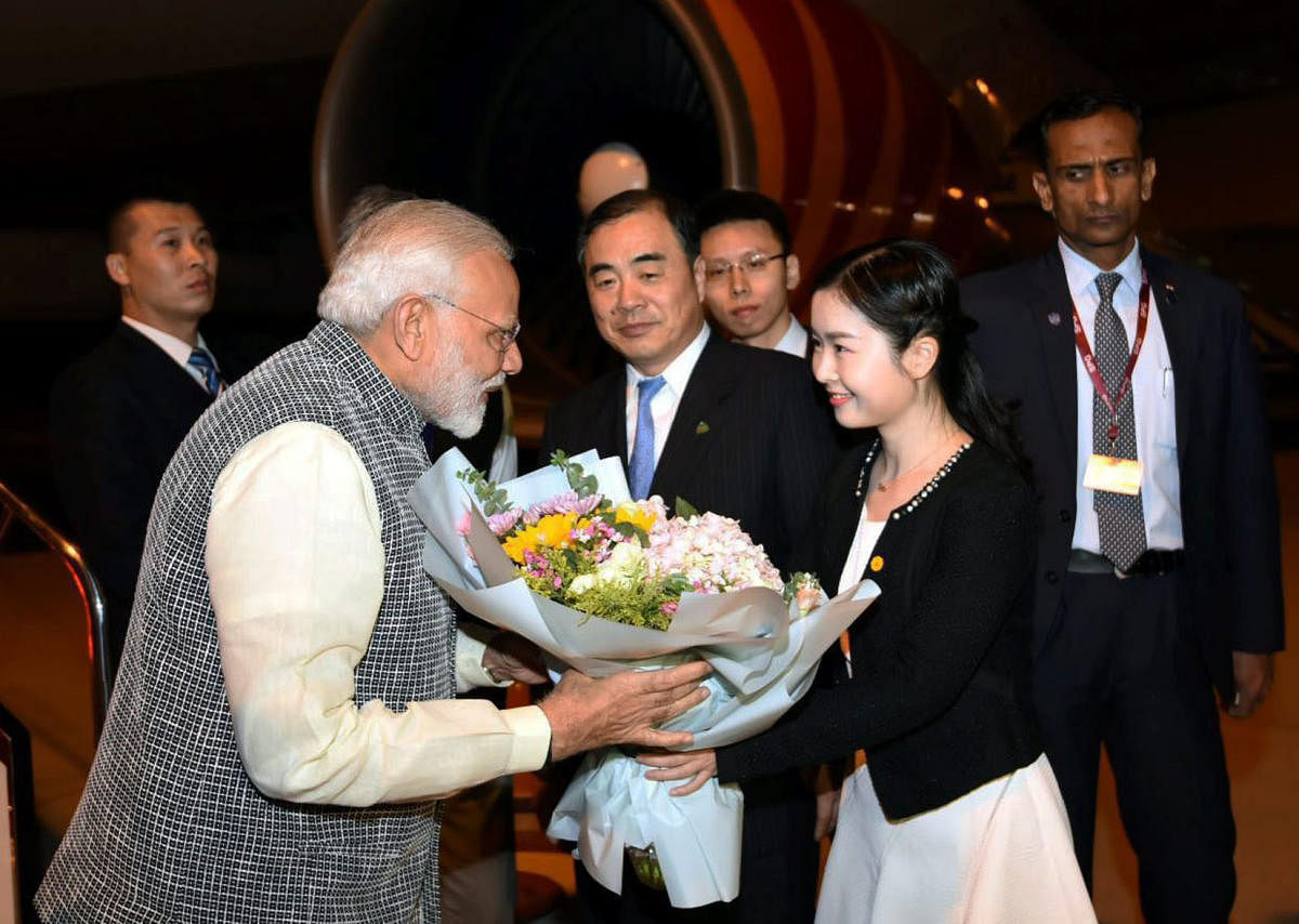 Prime Minister Narendra Modi being welcomed on his arrival in Wuhan, China on Thursday. Chinese Vice Foreign Minister Kong Xuanyou is also seen. PTI Photo