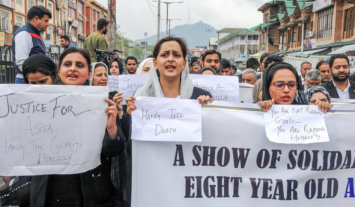 Members of Jammu and Kashmir High Court Bar Association display banners and placrads as they block a road during protest march against the Kathua rape and murder case, in Srinagar on Monday. PTI