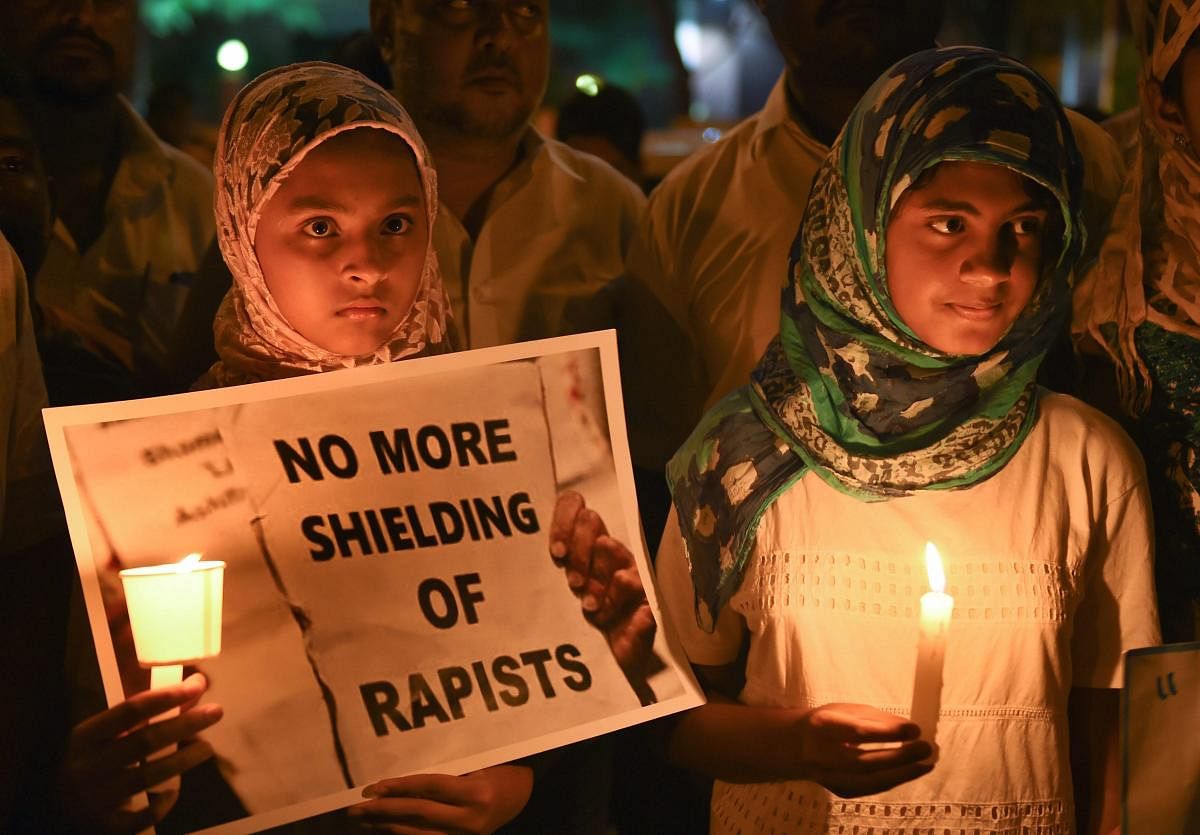 Girls take part in a candlelight vigil against the brutal rape and murder of 8-year-old Kathua girl and demanding for justice in Bengaluru on Saturday. (PTI Photo)