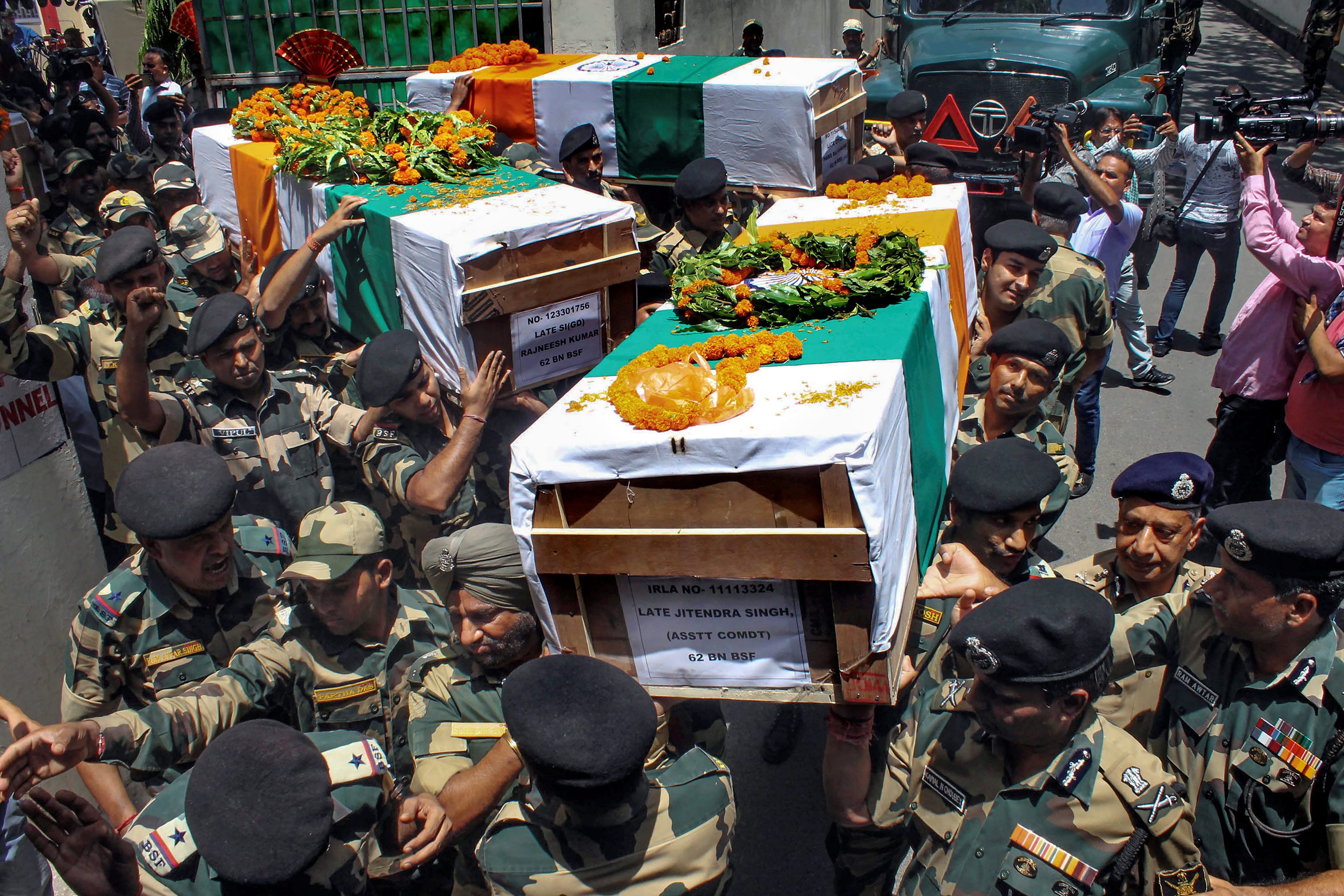 BSF officials and jawans carry the bodies of four BSF personnel, killed in Pakistani firing, after a wreath laying ceremony at Paloura BSF Headquarters in Jammu on Wednesday. PTI