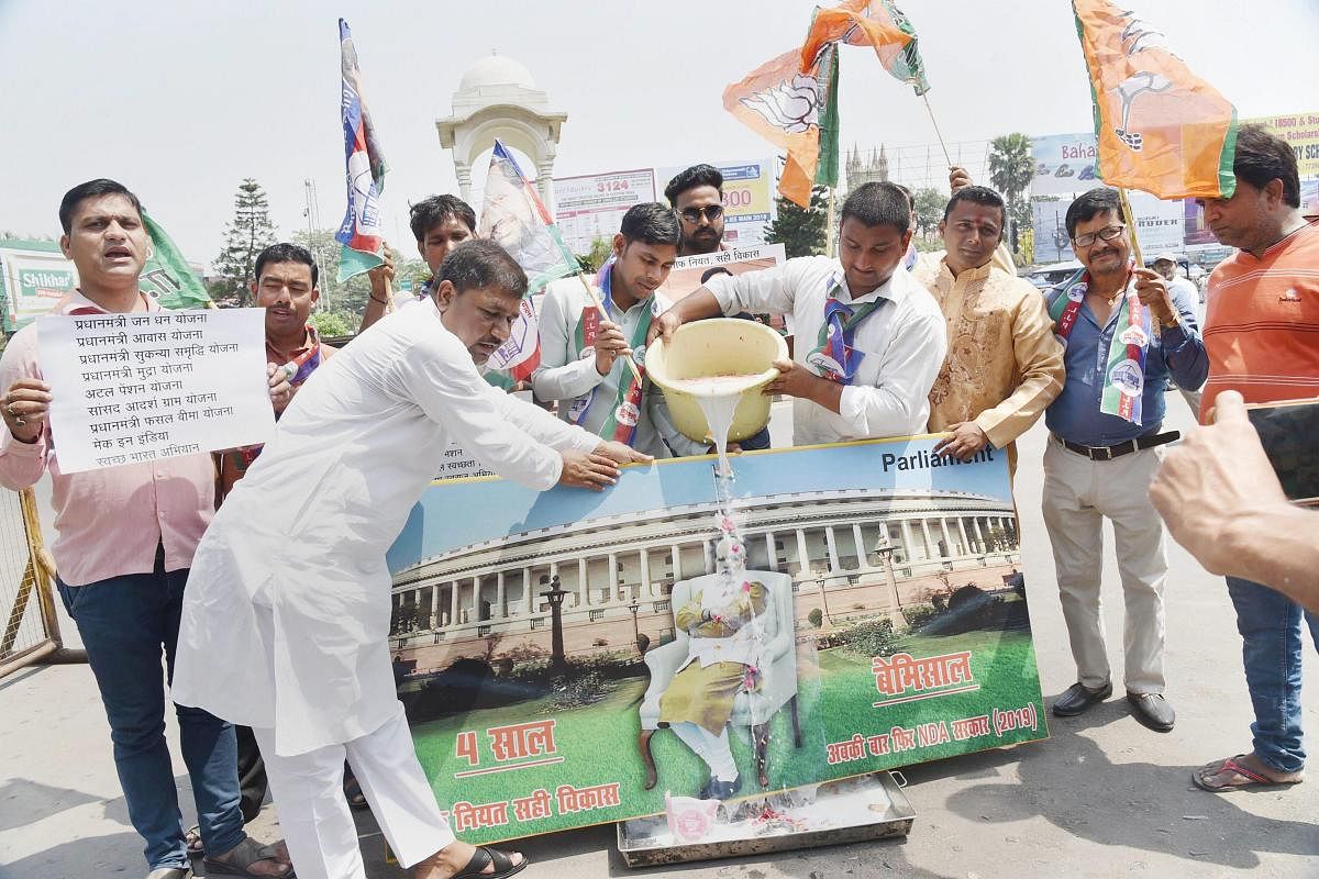 NDA supporters give a milk bath to a photo of PM Narendra Modi as they celebrate the 4th anniversary of the Narendra Modi-led BJP government in Patna on Saturday. (PTI Photo)